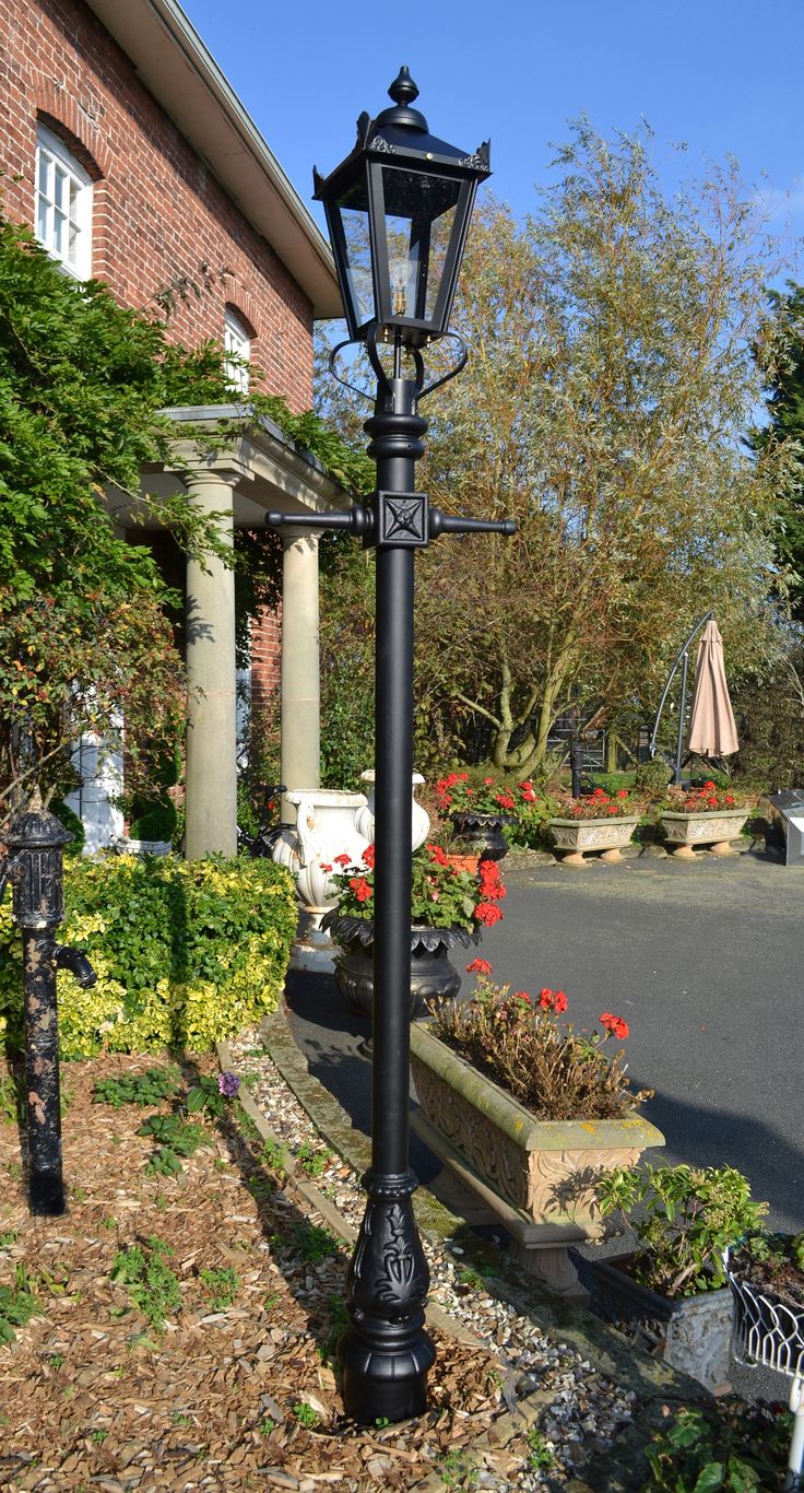 an old fashioned lamp post in front of a house