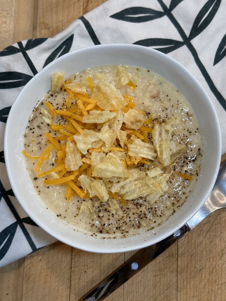 a white bowl filled with oatmeal and cheese on top of a table