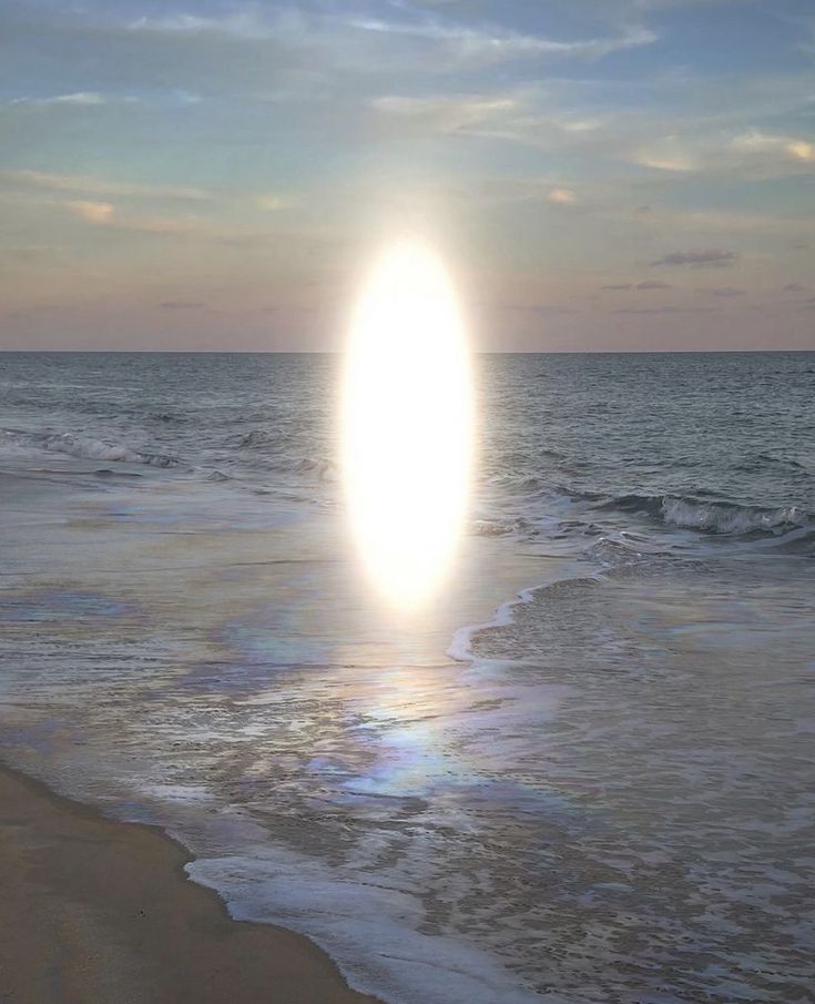 the sun is setting over the ocean with waves crashing on the beach and an object in the air