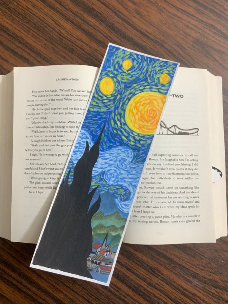 an open bookmark with the painting starry night on it sitting on top of a wooden table