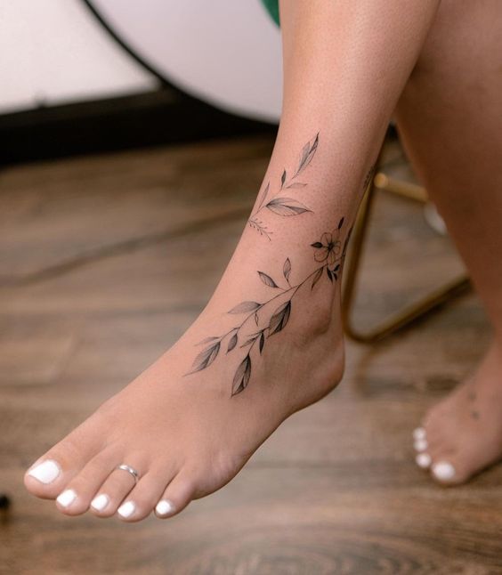 a woman's foot with a flower tattoo on it