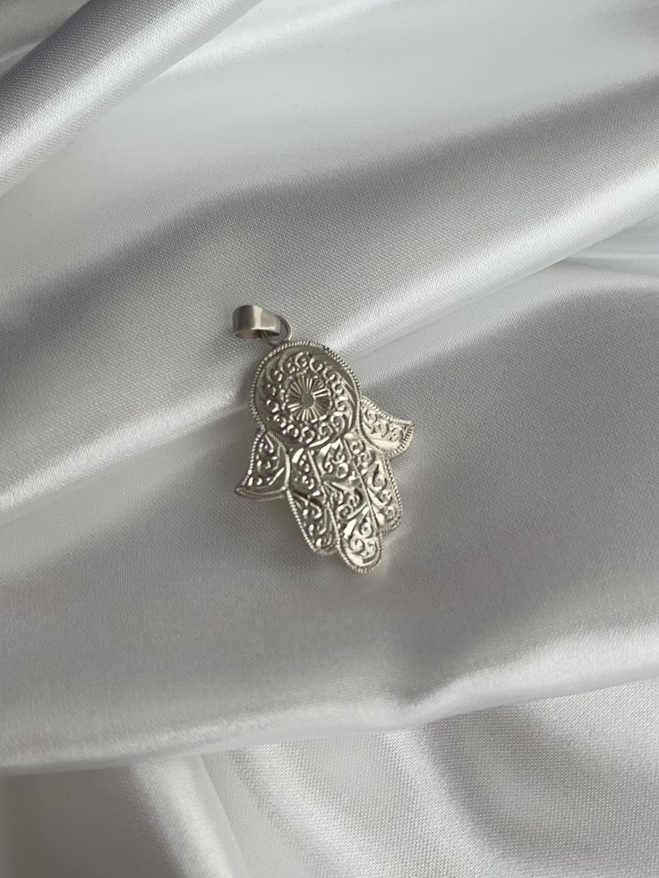 ♥ Click the link below to see more beautiful modern Hamsa Hands and Earrings: https://www.etsy.com/shop/FUENTESCOLLECTIONSNL Each Hamsa Hand pendant is handcrafted with precision and care, ensuring that no two pieces are exactly alike. The handmade nature of this pendant adds a unique touch and a sense of authenticity that mass-produced jewelry simply cannot replicate. Crafted from high-quality silver, this pendant features a beautifully detailed Hamsa Hand design that symbolizes protection, goo Symbolic Silver Dangle Jewelry, Silver Sterling Silver Large Pendant Jewelry, Symbolic Silver Pendant Earrings, Spiritual Silver Dangle Jewelry, Silver Symbolic Pendant Earrings, Spiritual Sterling Silver Charms, Silver Round Pendant Spiritual Charm, Handmade Spiritual Silver Charms, Spiritual White Gold Pendant Jewelry