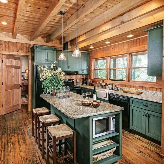 a kitchen with green cabinets and an island in the middle, surrounded by stools