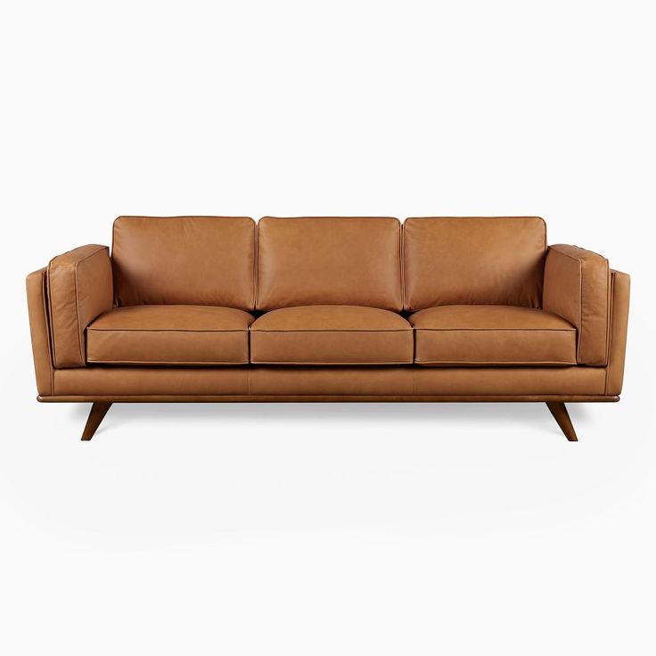 a tan leather couch with wooden legs on a white background and no one in the room