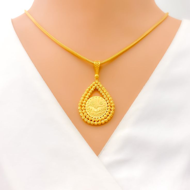 This stunning 22k gold pendant, weighing 7.8 grams, features an intricate engraved design that showcases exceptional craftsmanship. The yellow gold finish highlights the detailed engravings, making it a captivating accessory for any occasion. With a length of 1.75 inches, this pendant balances boldness and elegance perfectly. Ideal for those who appreciate detailed artistry and high-quality gold, this pendant can be paired with any chain of your choice. Its elaborate design and luxurious appeal make it a treasured addition to any jewelry collection, adding a touch of timeless beauty to any outfit. PRODUCT DETAILS Gold Purity(karat): 22k Gold Weight(grams): 7.8 Item Finish: Yellow Gold Pendant Length: 1.75" Chain: Not Included 22k Gold Engraved Medallion Jewelry, Engraved 22k Gold Medallion Jewelry, 22k Gold Engraved Medallion Necklace, Engraved 22k Gold Medallion Necklace, 22k Gold Medallion Necklace Engraved, 22k Gold Engraved Necklace For Ceremonial Occasions, Gold Oval Pendant Necklace For Ceremonial Occasions, Traditional Coin Pendant Jewelry For Formal Occasions, Traditional Coin Pendant Jewelry For Formal Events