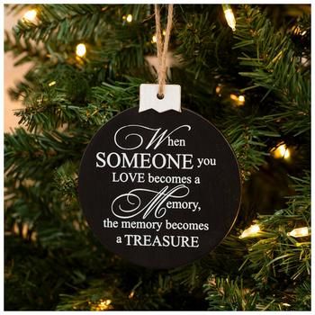 a black ornament hanging from a christmas tree that says, when someone you love becomes memory, the memory becomes a treasure