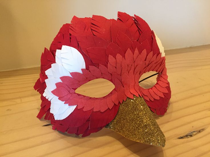 a red and white mask sitting on top of a wooden table