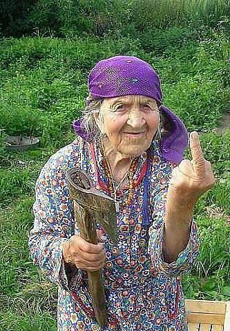 an older woman is holding a fish and giving the peace sign