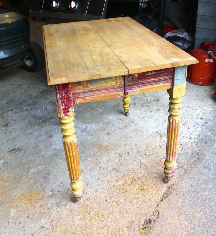 an old wooden table sitting in a garage