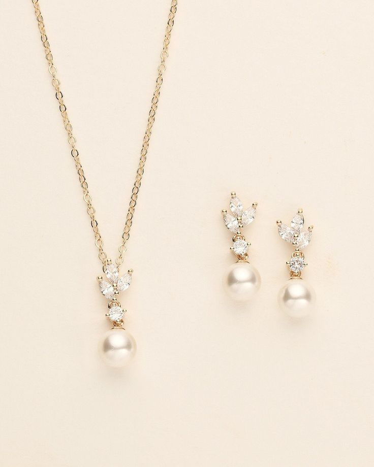 three pieces of jewelry on a white surface, including a necklace and earring set