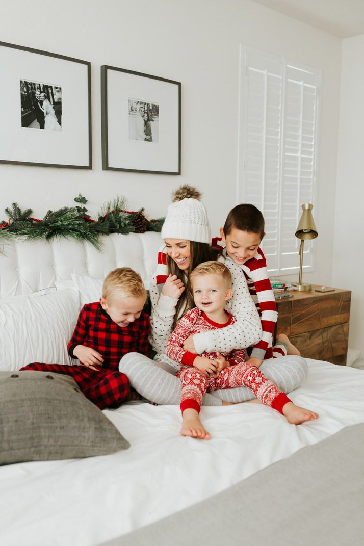 three children are sitting on the bed with their mother and two other kids in pajamas