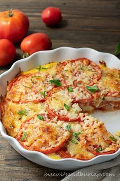 a casserole dish with tomatoes and cheese on the side, ready to be eaten