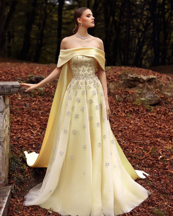 A Feminine pastel yellow color dress with flowing maxi cut made from tulle & Mikado cape. This dress is fully embroidered with scattered… | Instagram Gown With Cape, Yellow Evening Dresses, Grey Evening Dresses, Champagne Evening Dress, Gold Evening Dresses, Satin Evening Gown, Green Evening Dress, Pink Evening Dress, White Evening Dress