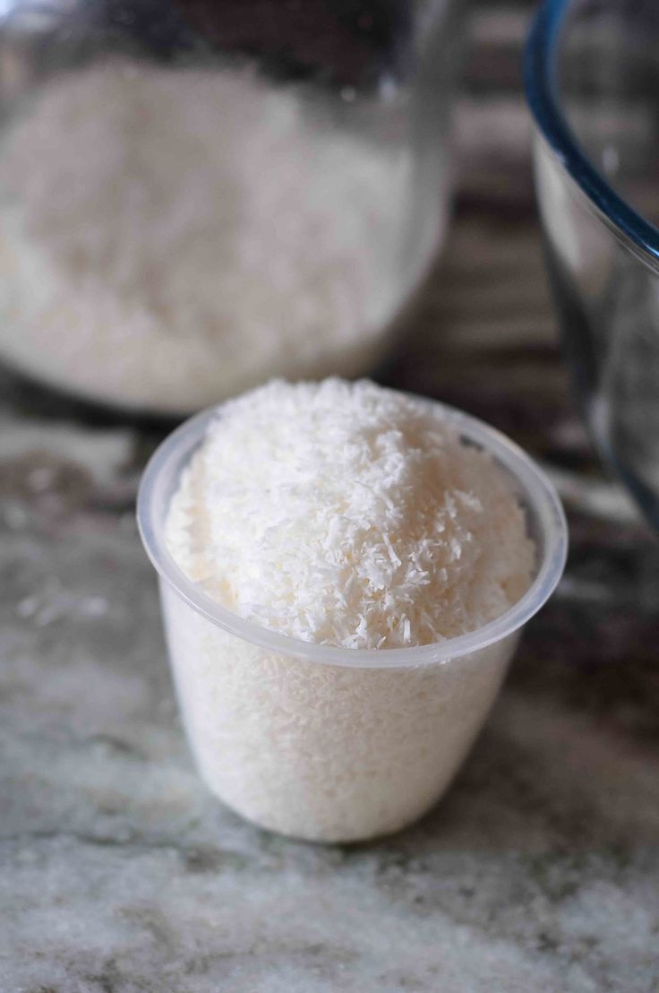 two bowls filled with white rice on top of a counter next to a measuring cup