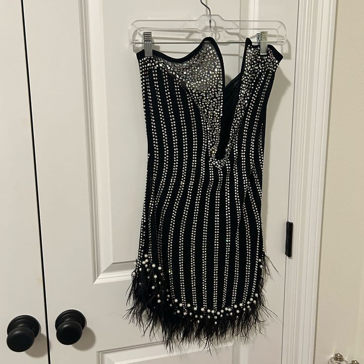 a black and white flap dress hanging on a door hanger in front of a closet