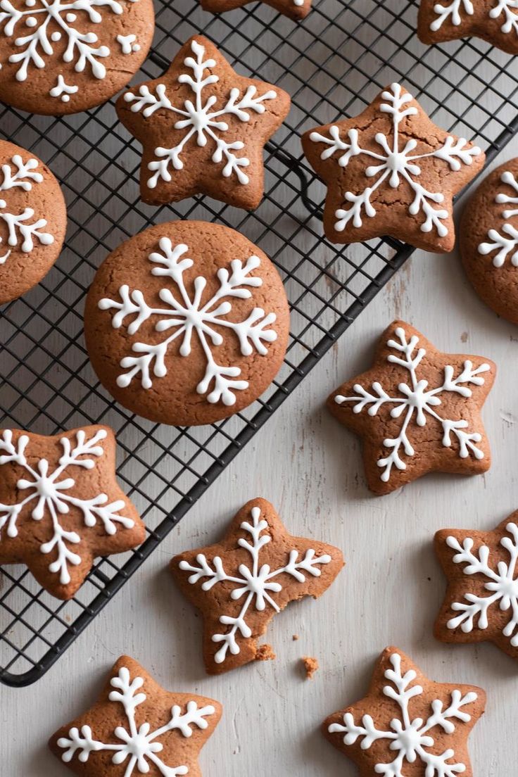 some cookies with white snowflakes are on a cooling rack