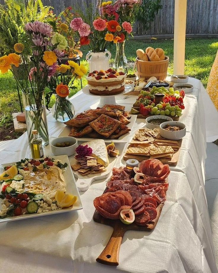 a table filled with food and flowers in vases on top of it's sides