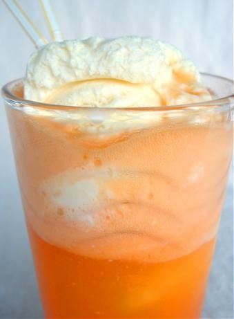 an orange drink with whipped cream on top and straws sticking out of the top