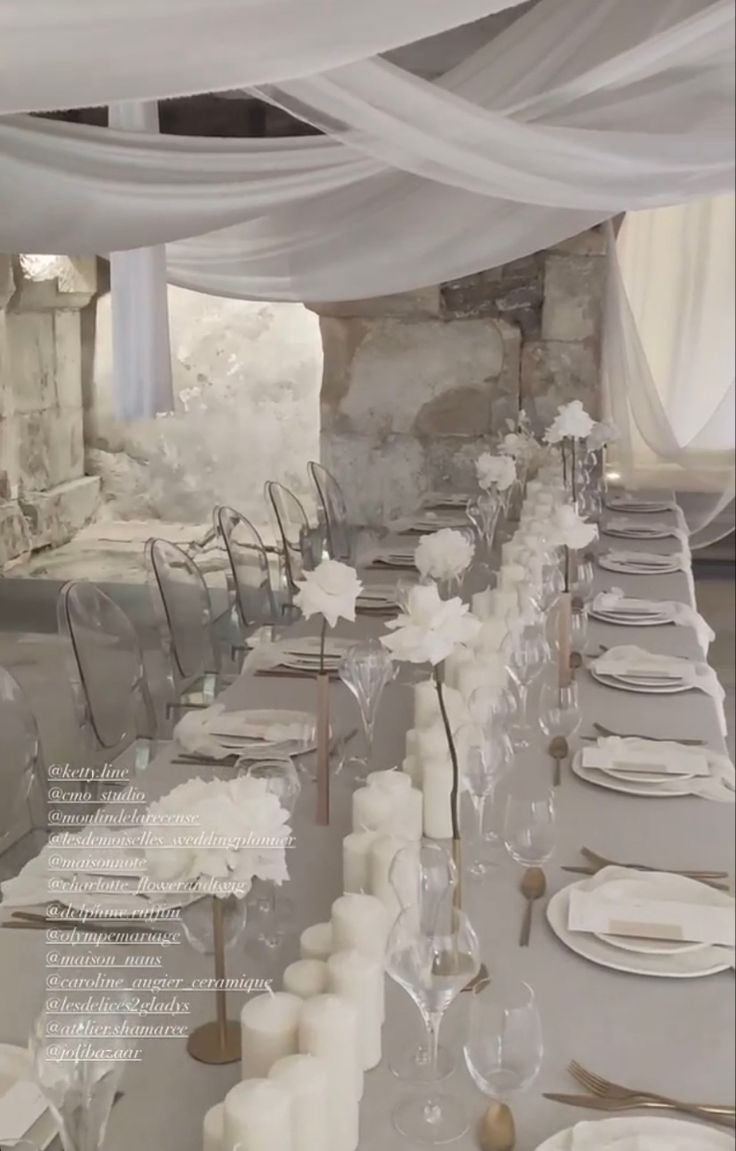 the tables are set with white linens and place settings for guests to sit at