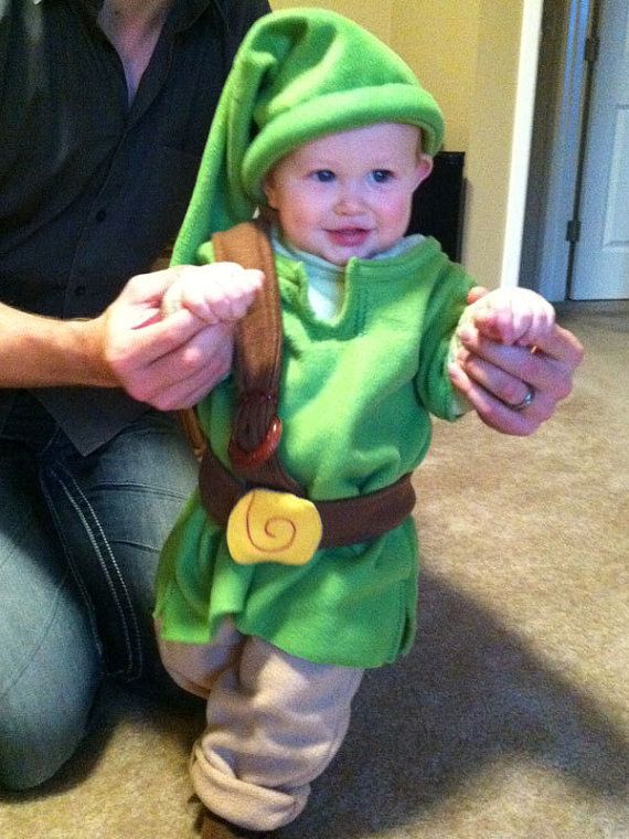 a man kneeling down next to a baby in a costume