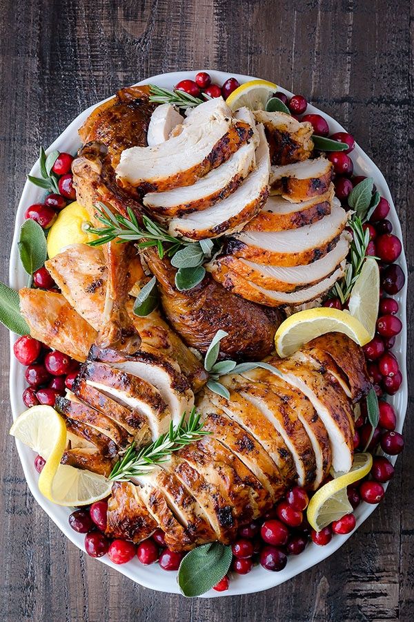 a platter filled with sliced turkey and cranberries