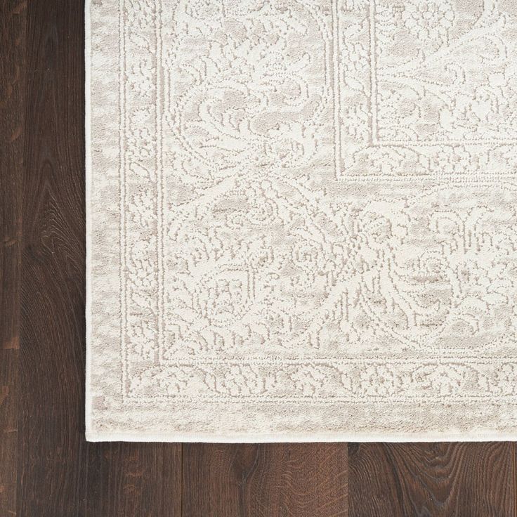 a white rug on top of a wooden floor