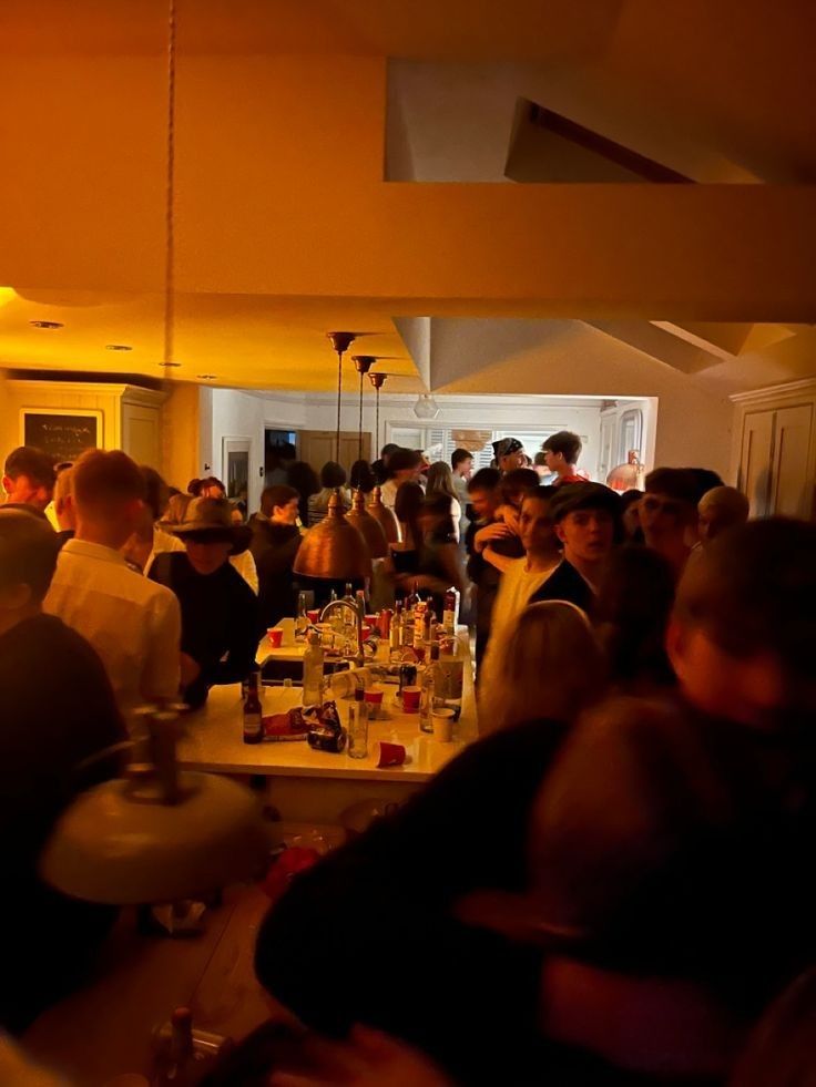 a group of people sitting around a bar with drinks on the table and in front of them