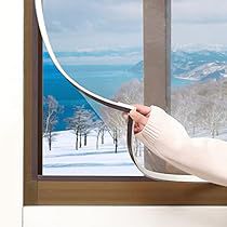 a woman holding a large white object in front of a window