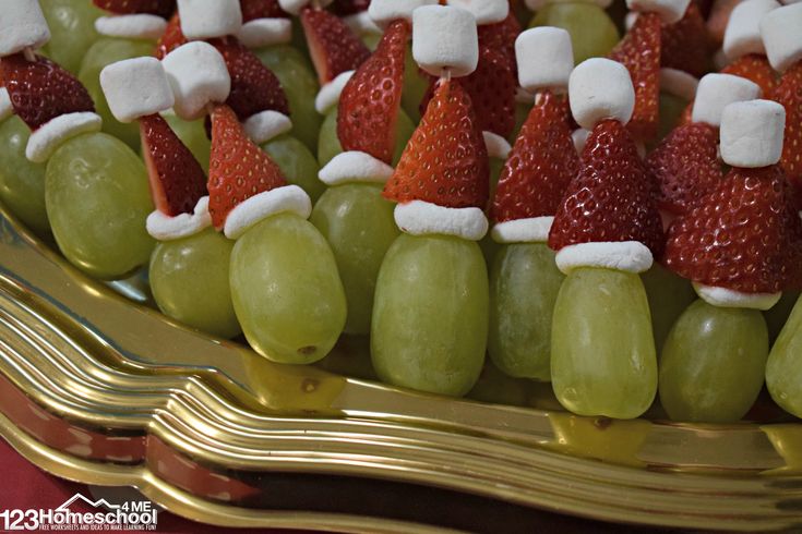 grapes and strawberries are arranged in the shape of santa's hats on a platter