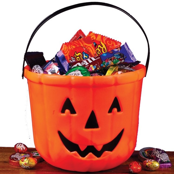 a pumpkin bucket filled with candy and candies