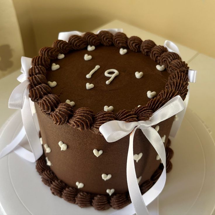 a chocolate cake decorated with white hearts and the number nine on it's side