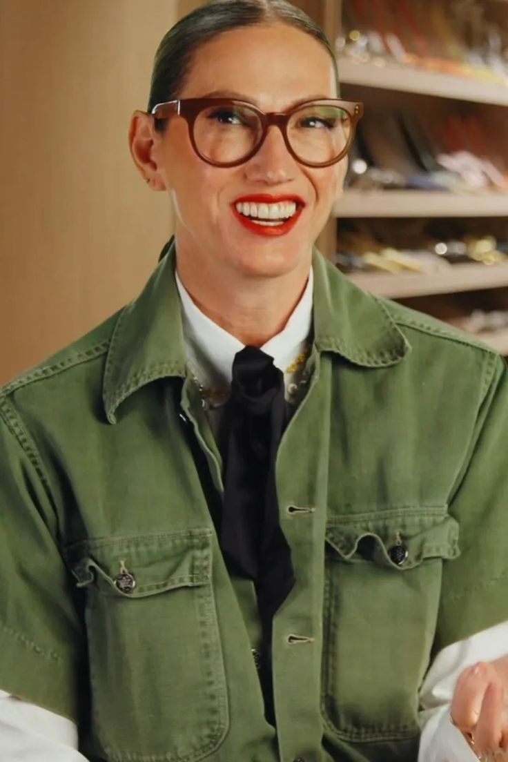 a woman wearing glasses and a green jacket