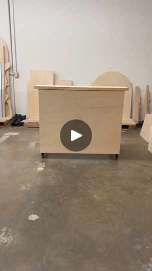 a wooden counter sitting on top of a floor next to boxes and other items in a room