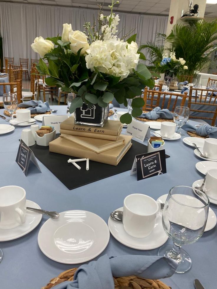 the table is set with books, cups and saucers