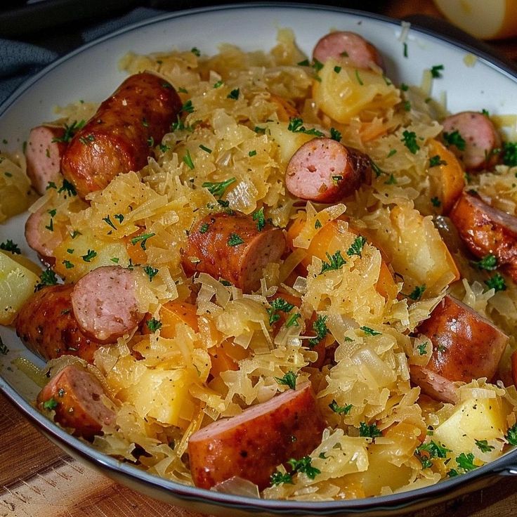 a bowl filled with sausage and sauerkraut on top of a wooden table