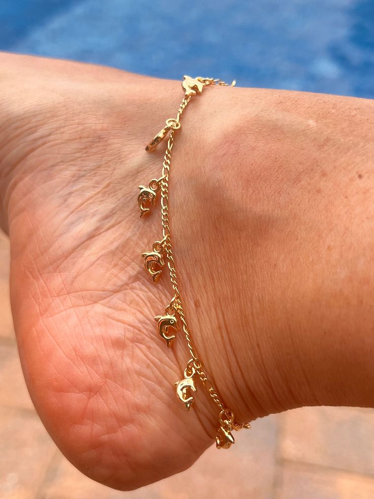 Dive into summer with our enchanting Gold-Filled Dolphin Charm Ankle Bracelet! This delightful piece captures the playful spirit of dolphins and adds a touch of elegance to any summer outfit. Perfect for beach days, summer soirées, or casual everyday wear, this ankle bracelet is designed to make a statement. Add a splash of charm to your summer style with the Gold-Filled Dolphin Charm Ankle Bracelet. Shop now and enjoy our exclusive discount! Gold Strand Anklets For Vacation, Spring Gold Anklets For The Beach, Adjustable Gold Strand Anklets, Gold Anklets For Beach Season, Adjustable Gold Anklets For Beach Season, Starfish Charm Anklet For Vacation, Blue Starfish Charm Anklet For Vacation, Gold Anklet With Lobster Clasp, Fall Jewelry Trends