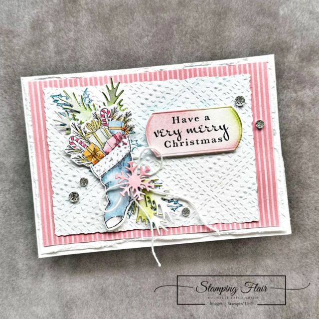 a close up of a christmas card on a gray surface with the words have a very merry christmas