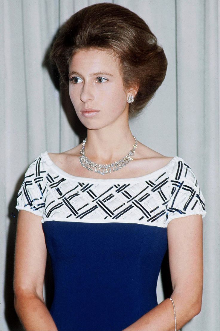 an old photo of a woman in a blue and white dress with a diamond necklace