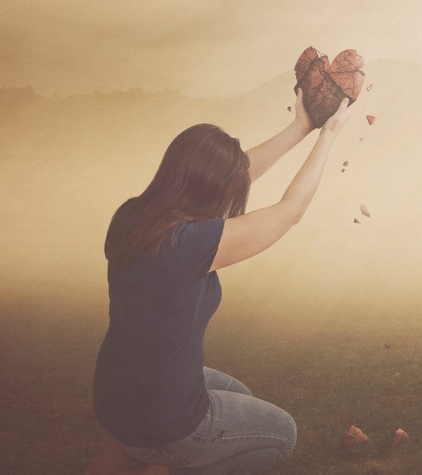 a woman kneeling down with her hands in the air and throwing rocks into the air