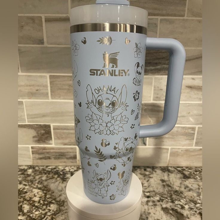 a blue and white coffee cup sitting on top of a counter next to a tile wall