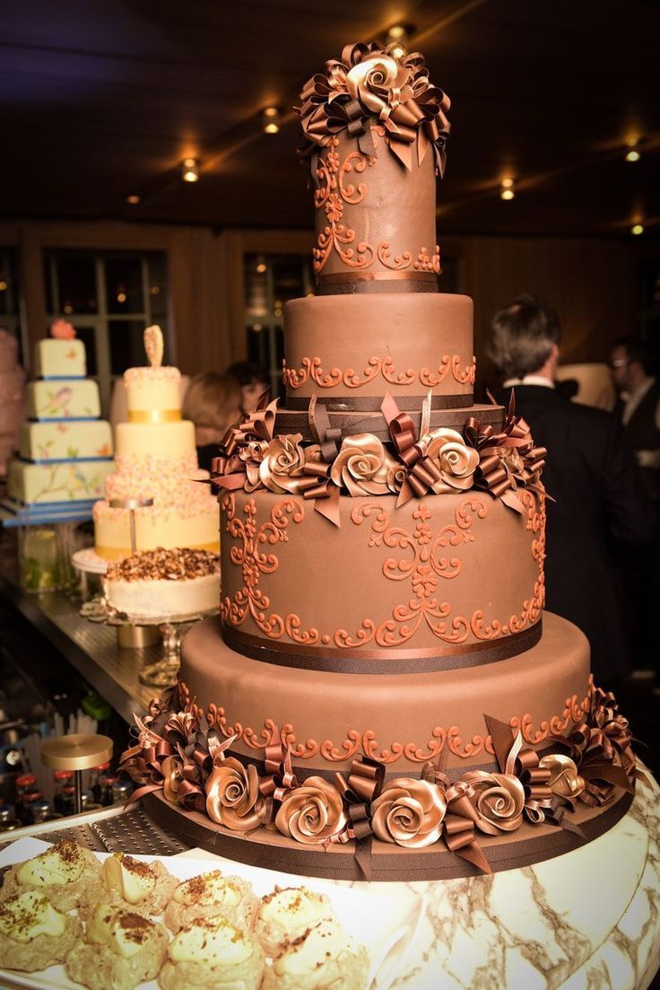 a three tiered chocolate cake sitting on top of a table