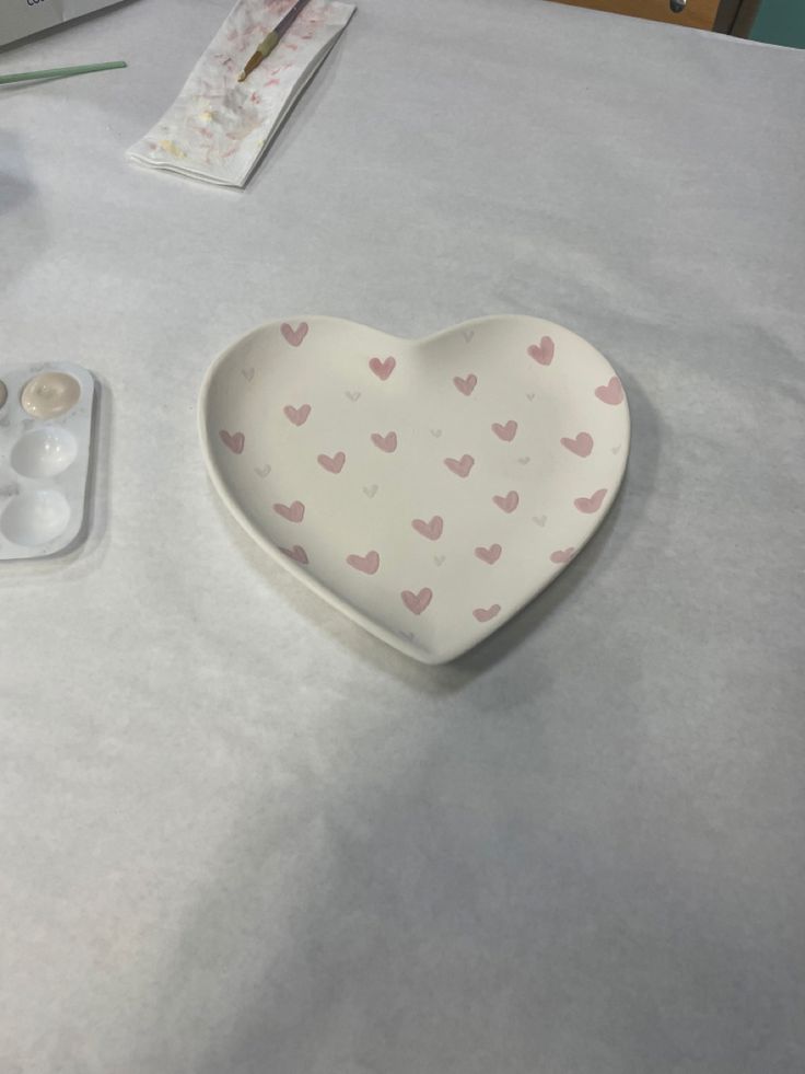 a heart shaped dish sitting on top of a table