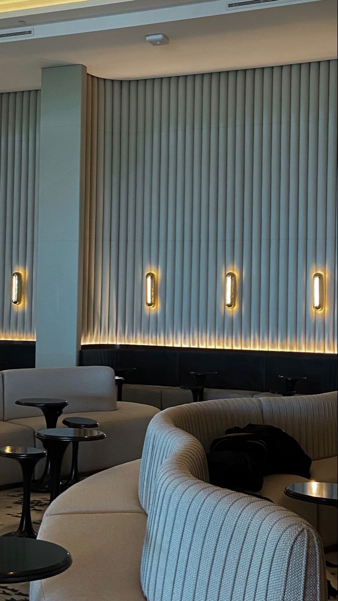 the interior of a modern hotel lobby with white and black furniture, striped walls and flooring