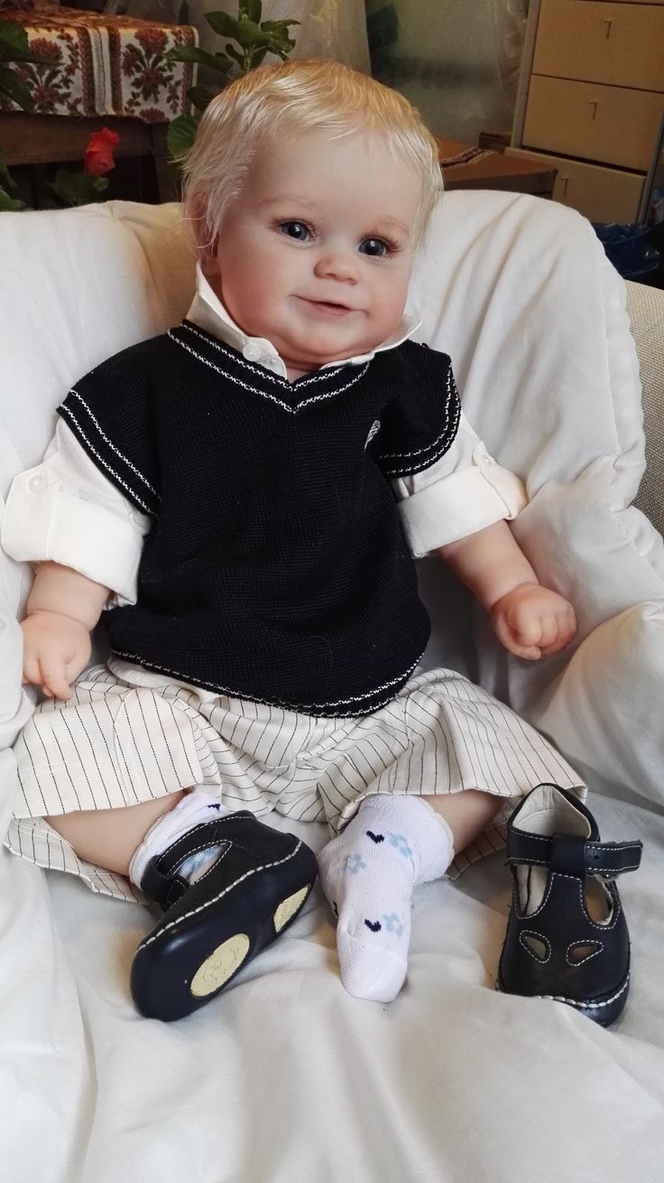 a baby doll sitting on top of a white chair