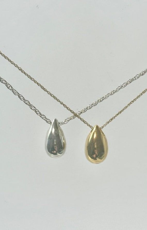 This beautiful mini teardrop pendant is a unique way to hold a loved one close. This pendant can hold a small amount of cremains, lock of hair, or dirt from the sacred burial grounds. This piece comes on an 18" matching chain.  size 1/2 inch engraving is ♥we are able to engraving up to 3 letters 2 sides ♥Engraving can be done in block or script font and in uppercase or lowercase as well as numbers GOOD TO KNOW: ♥ Available in 14k plated gold or a Sterling Silver ♥THIS PENDANT CAN BE ENGRAVED-SEE Everyday Teardrop Pendant Jewelry, Classic Teardrop Drop Necklace Gift, Classic Silver Teardrop Pendant, Classic Teardrop Drop Necklace For Anniversary, Classic Silver Drop Necklace, Silver Water Drop Earrings As Gift, Silver Pear Drop Necklace For Anniversary, Hypoallergenic Teardrop Pendant For Everyday Wear, White Gold Teardrop Pendant Drop Necklace