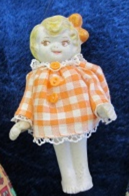 an orange and white doll is sitting on a blue blanket