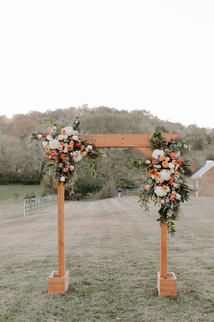 an orange and white wedding arch decorated with flowers