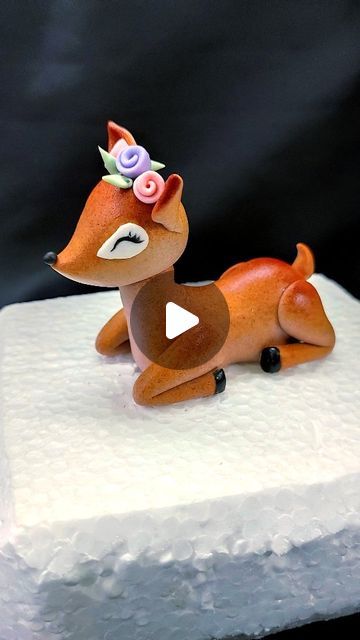 a small toy deer laying on top of a white cake