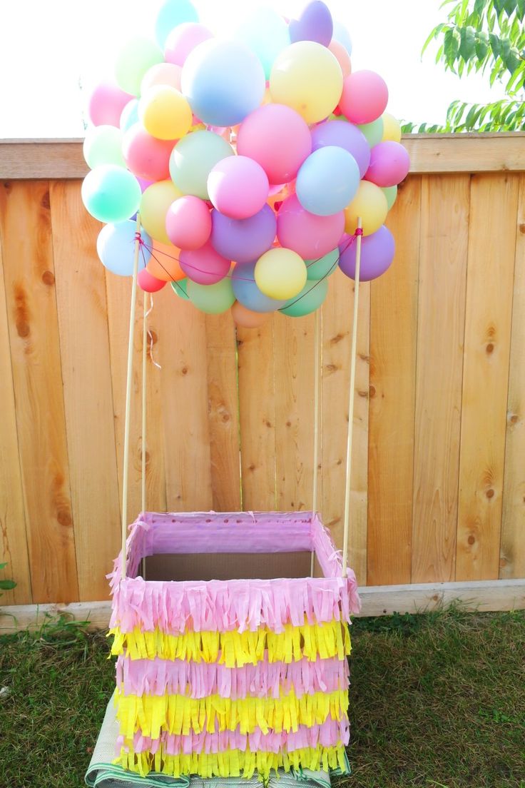 a bunch of balloons that are in a box on the grass with some string attached to it