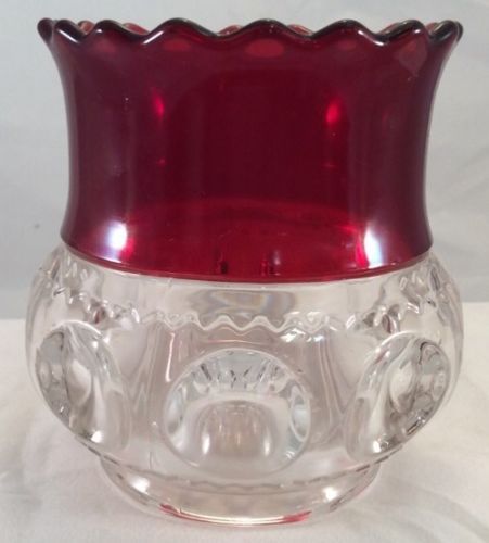 a red glass vase sitting on top of a white table